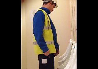 Construction worker pissing at urinals