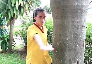 Ma asiático chica patadas un árbol