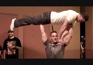 Bodybuilder presses man over his head