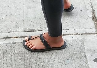 Ebony feet in sandals waiting for bus